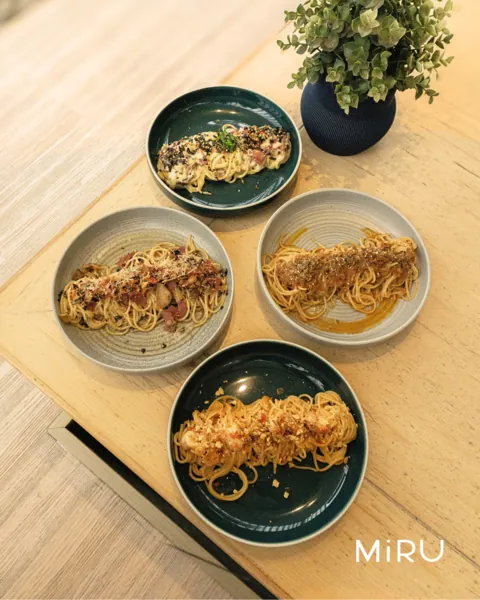 Four MiRU spaghetti plates photographed from above on a wooden table